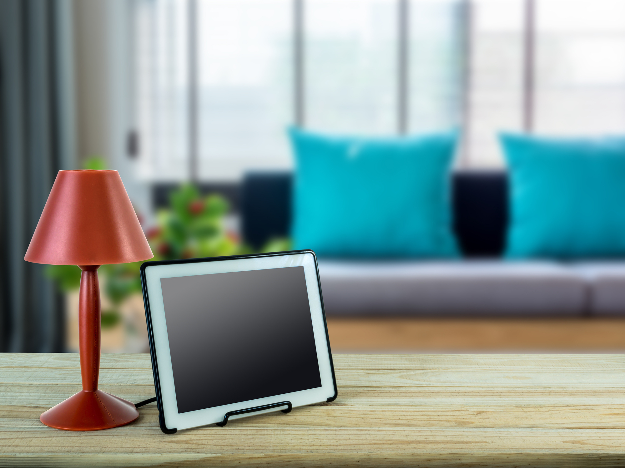 red lamp and digital photo frame with a living room in the background