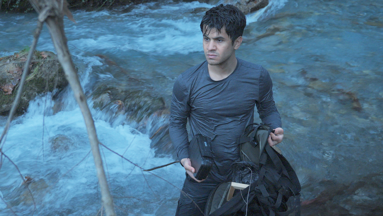 A man in the wilderness by a river