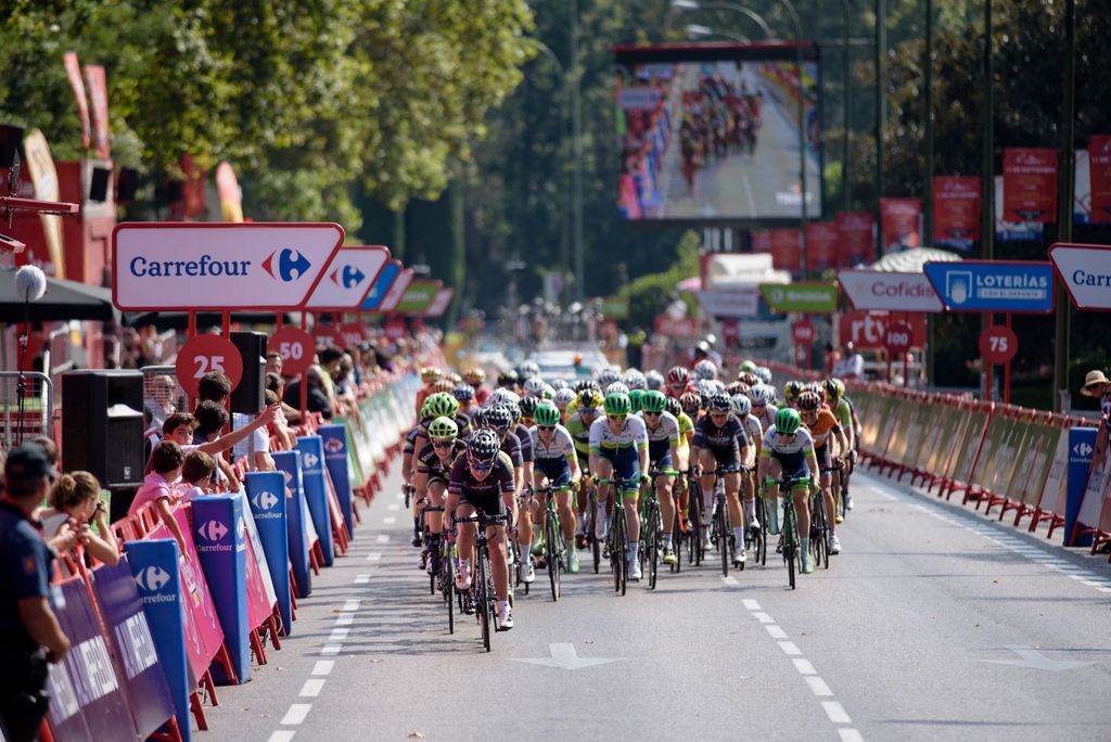 The peloton comes into the finish straight for the final lap