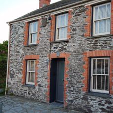 sloping roof house with exposed grey with orange brick walls