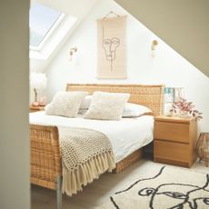 Loft conversion bedroom with rooflights with rattan bed, and textured accessories