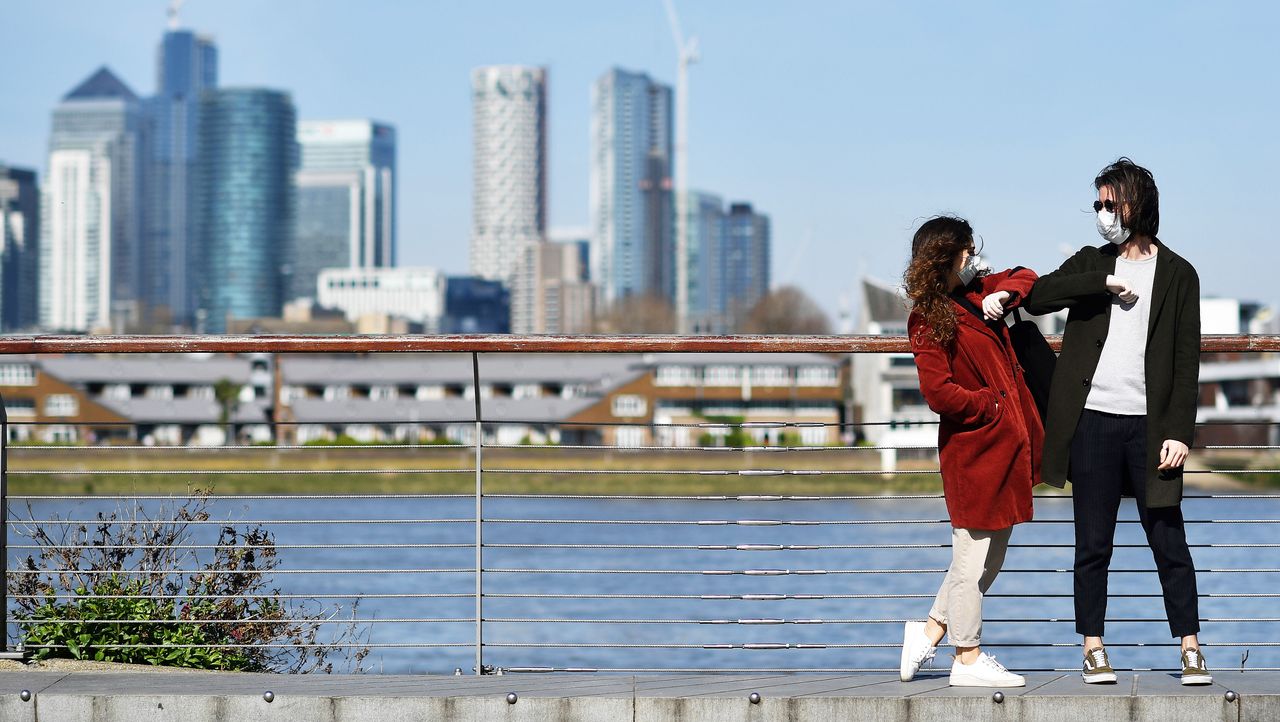 Two people don masks in London’s Docklands