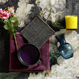 room with floral printed wallpaper on wall and glass vase