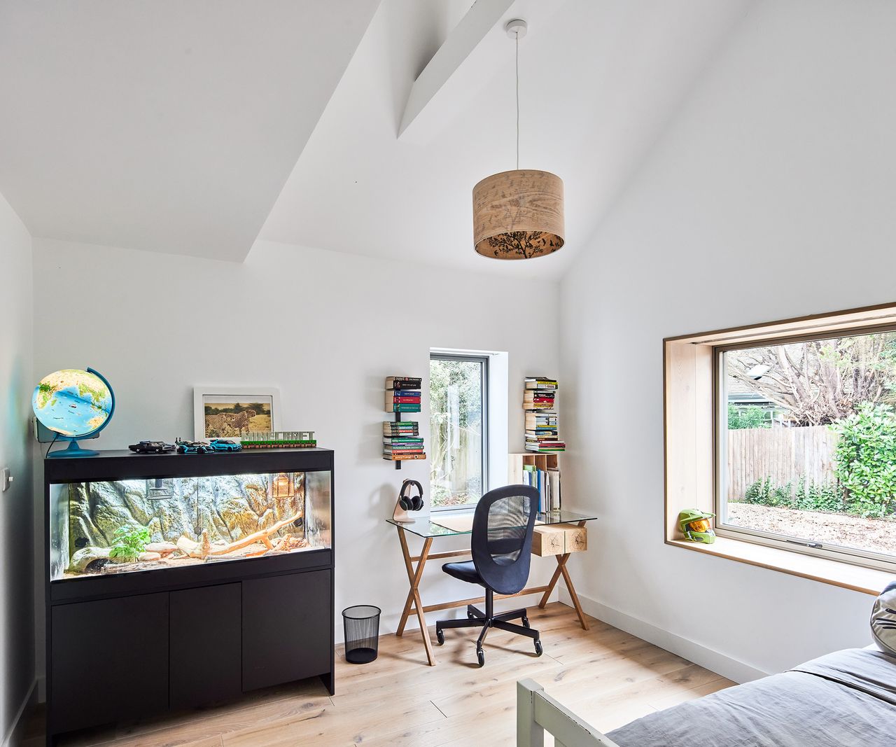 A young person's bedroom with a desk and fish tank