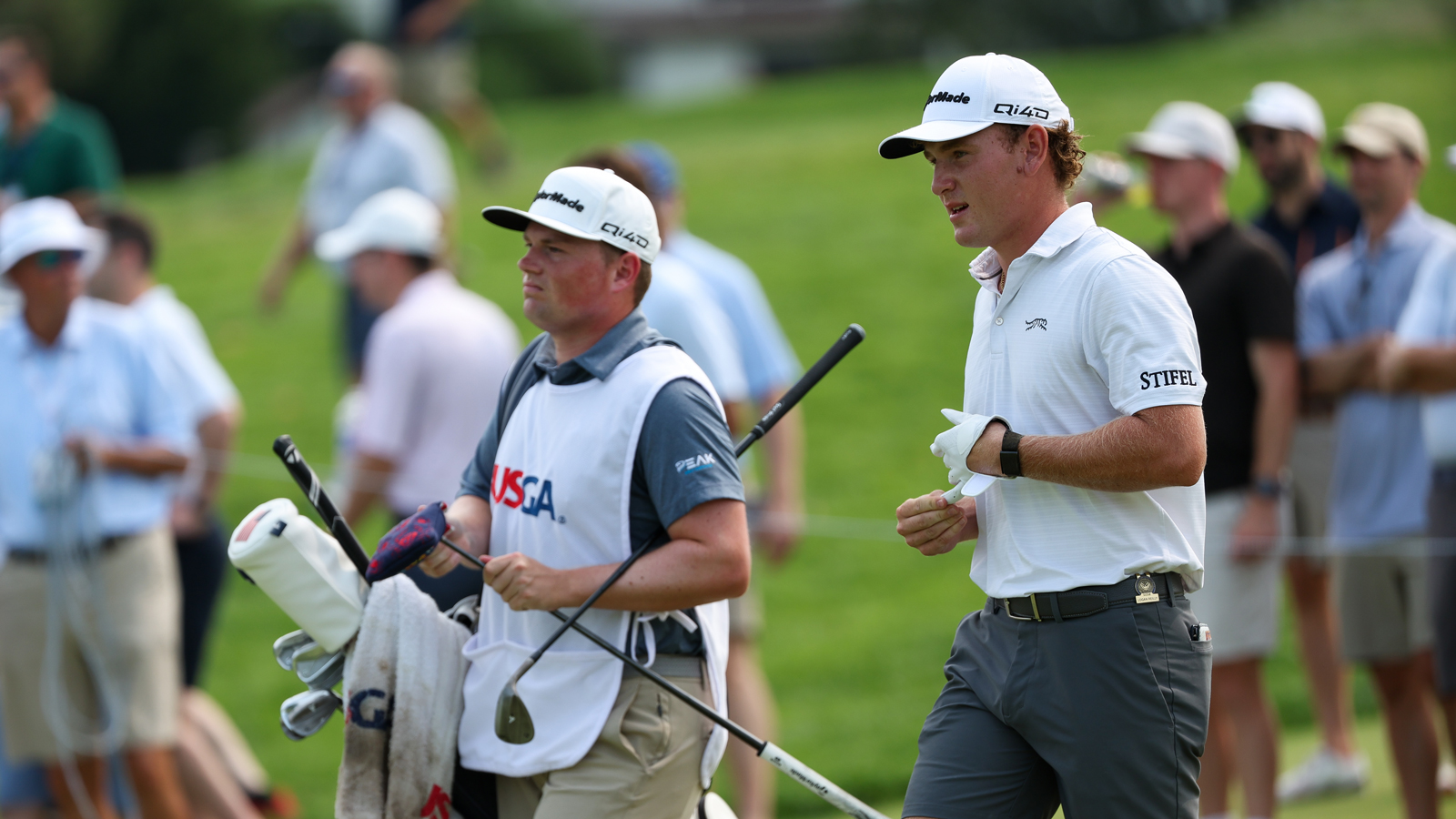 Logan Reilly walks alongside his caddie during the US Amateur