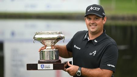 Patrick Reed smiles while holding up the Asian Tour's Hong Kong Open trophy