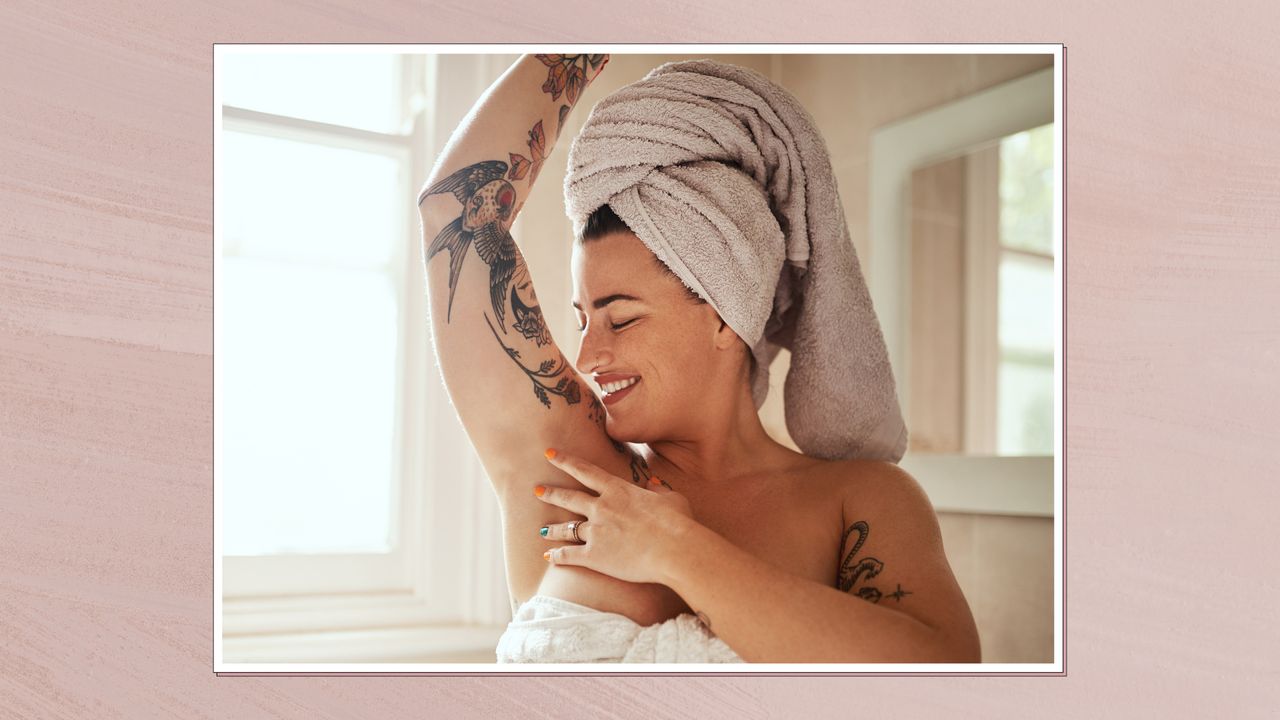 Image of a woman in a towel with her hair also wrapped in a towel, raising her arm above her head touching her underarm, in a white frame and set against a dusky pink background