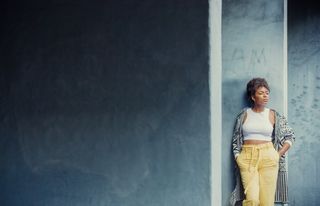 Portrait of a woman by wall in daylight