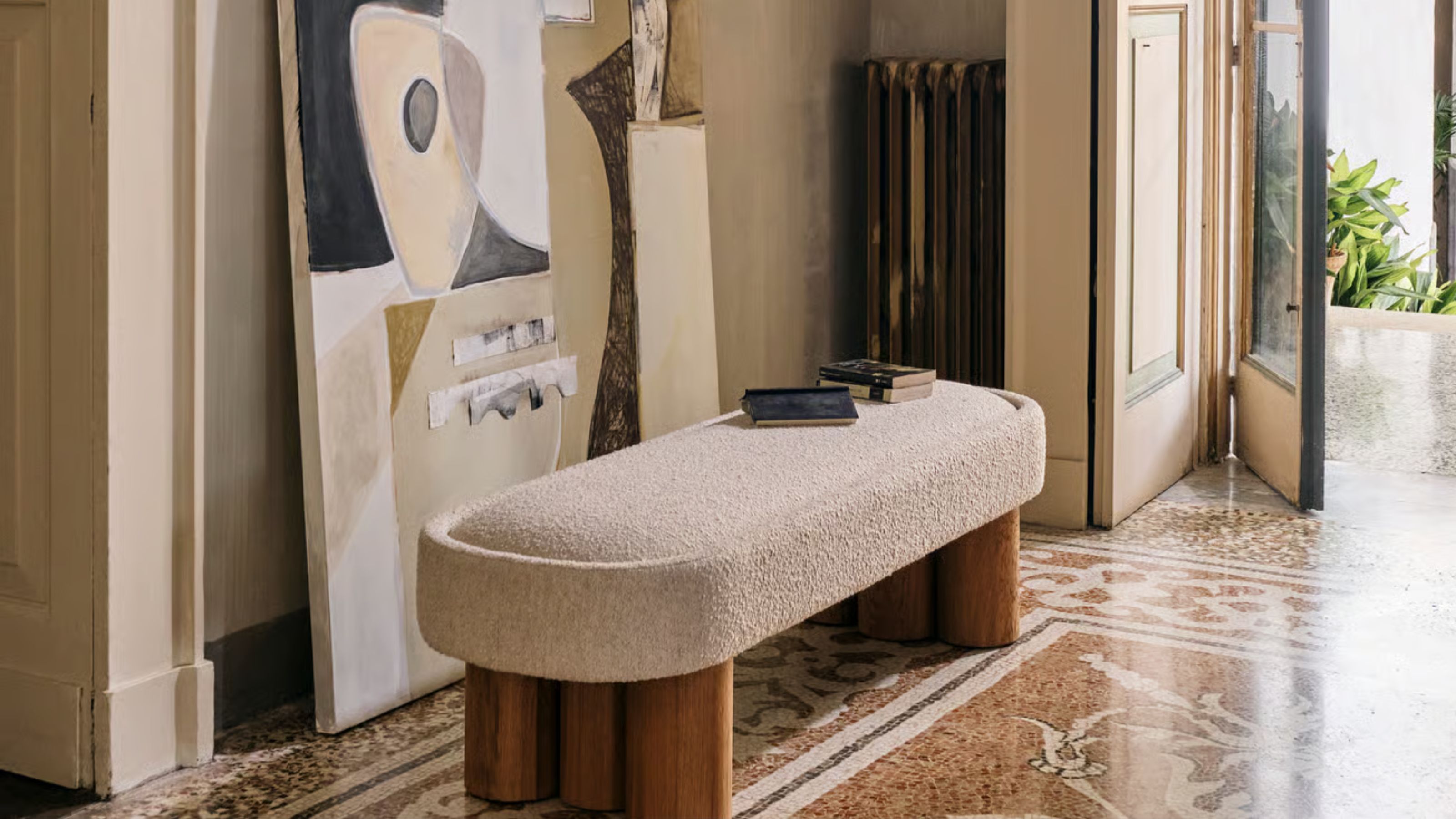 entryway with mosaic floors, an artwork leaning against a wall, a radiator, and a boucle entryway bench