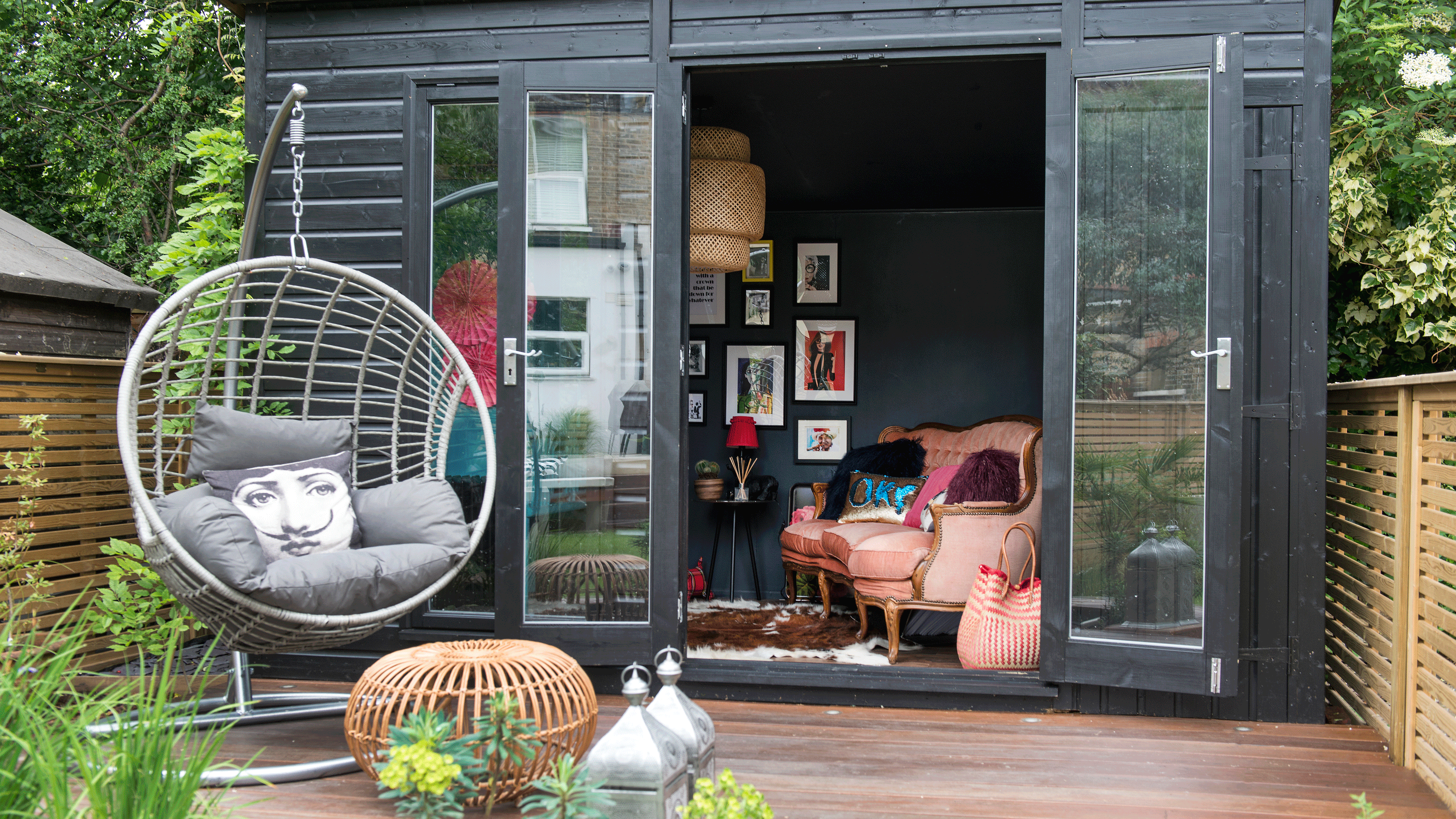 White shed at the back of a small garden