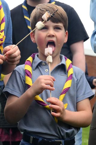 Prince Louis of Wales eats a marshmallows as he takes part in the Big Help Out, during a visit to the 3rd Upton Scouts Hut in Slough on May 8, 2023