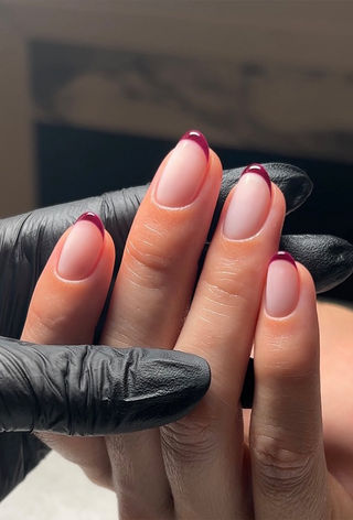 A French manicure with burgundy tips by Georgia Rae.