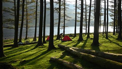 Campers wake as the sun rises over Buttermere Lake in the Lake District 