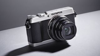 Olympus Stylus SH-1 against a grey background