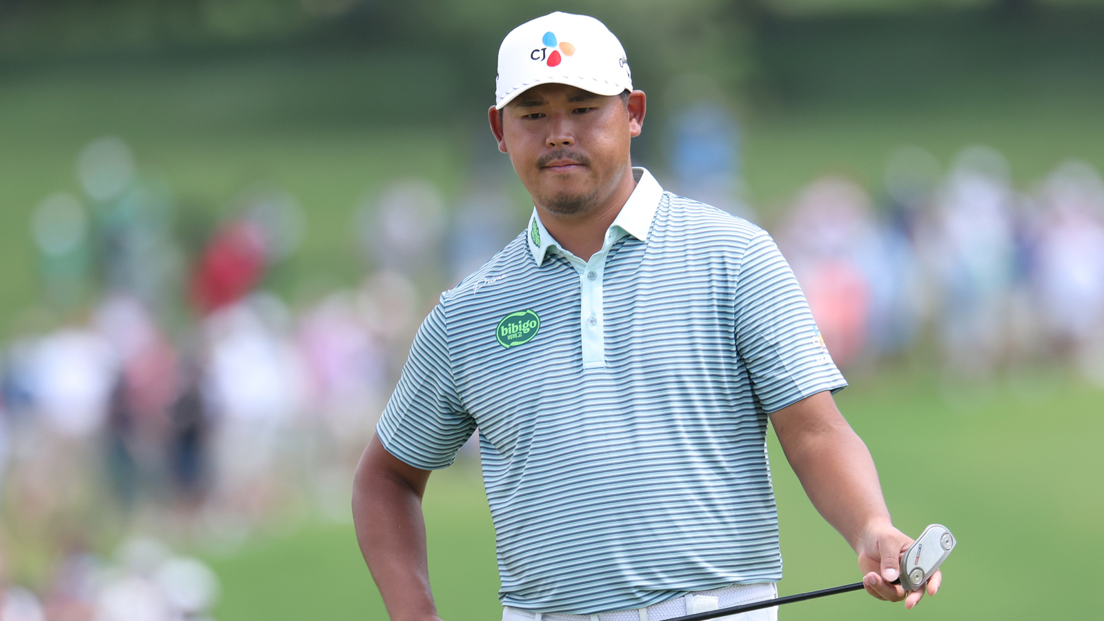 Si Woo Kim walks on the green with a putter