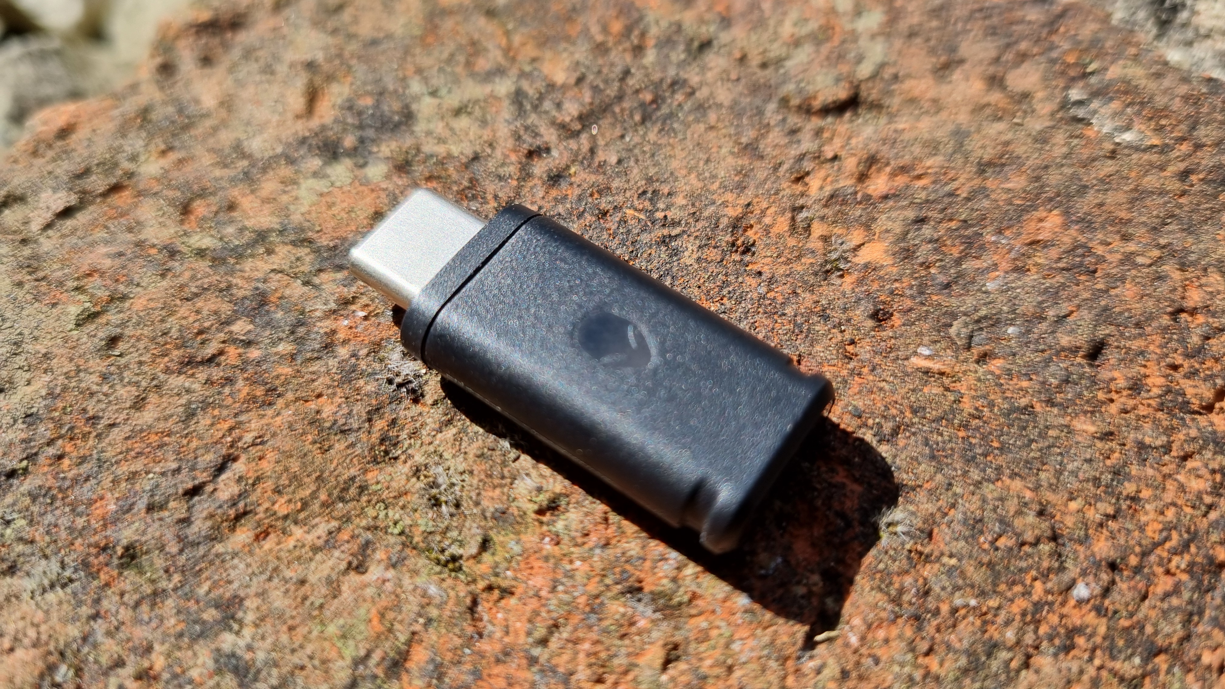 The wireless receiver for the Alienware Pro Wireless gaming mouse, on a brick wall