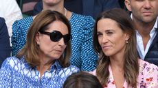 Carole Middleton and Pippa Middleton talk to each other as they attend day thirteen of the Wimbledon Tennis Championships in 2019