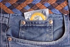 A close up of a condom in a jeans pocket