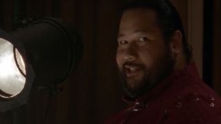 Cooper Andrews smiling and looking at the camera with a light behind him in the Walking Dead