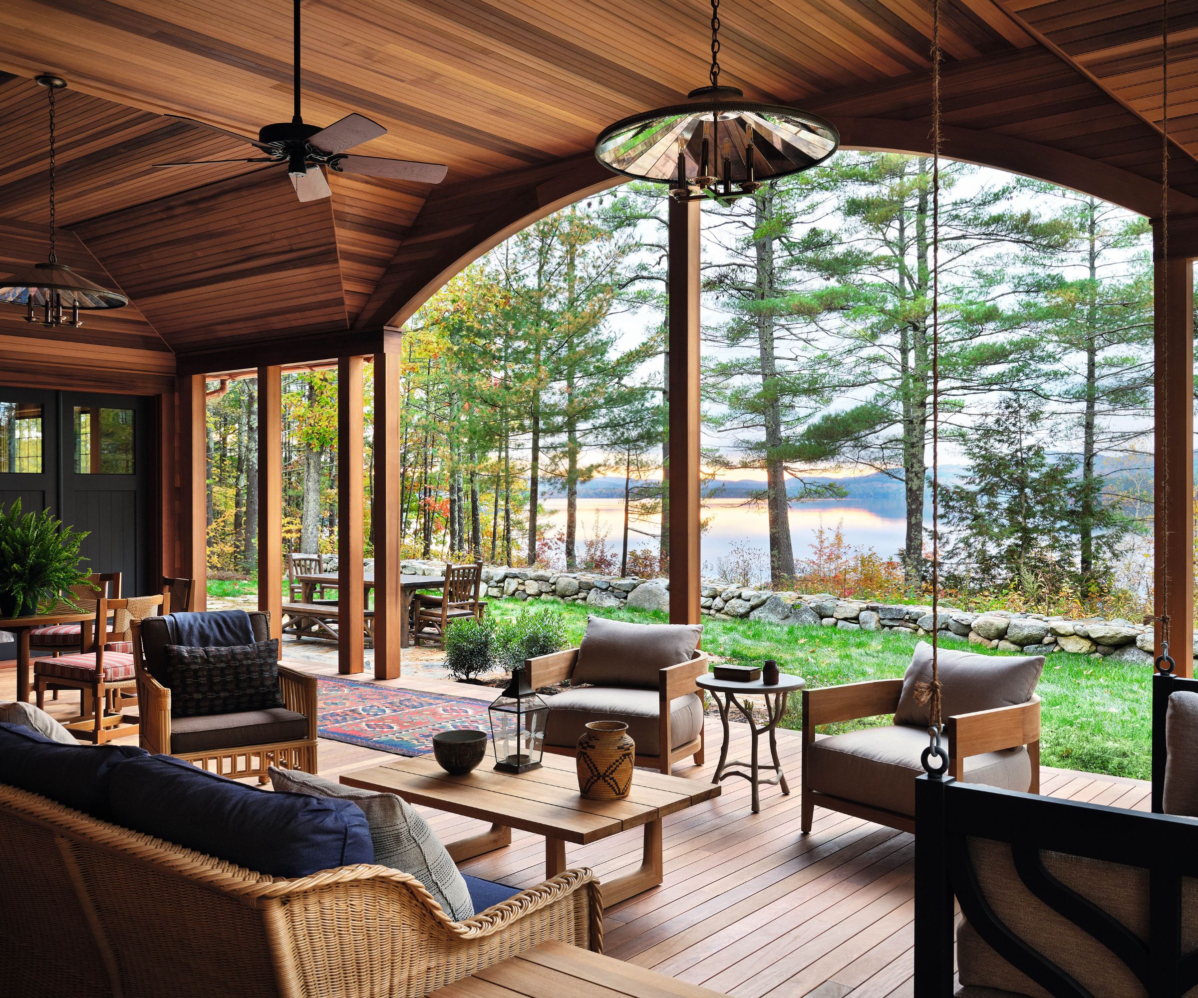 Wood clad porch with rattan furniture, coffee table and swing