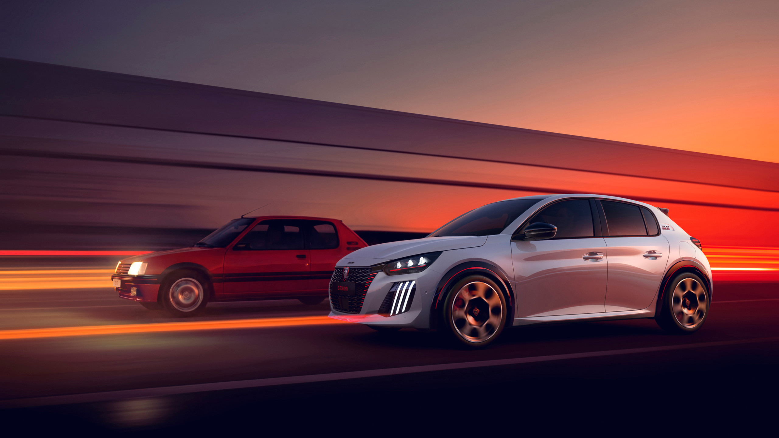 The original 205 GTi alongside the new Peugeot E-208 GTi