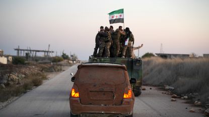 Syrian rebels raise their flag after capturing Aleppo