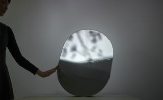 Hand touching a reflective object