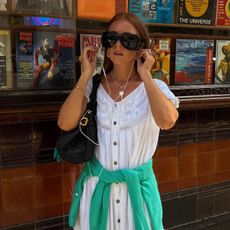 Creator @rebeccaferrazwyatt wearing a white dress and green jumper with glowing skin