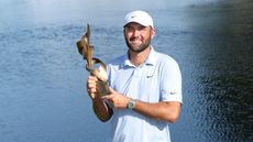 Scottie Scheffler holds the FedEx St. Jude Championship trophy
