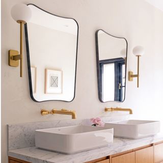 2 bathroom sinks, mirrors and wall lights, with white and grey tilting