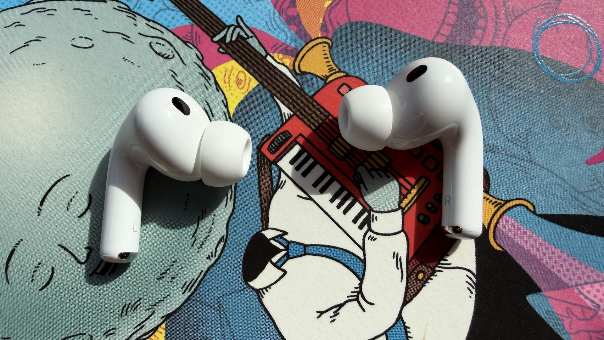 The AirPods Pro 3 earbuds from Apple against the pages of a graphic novel.