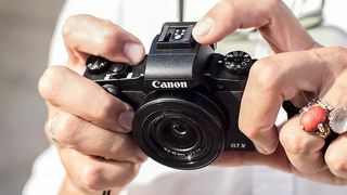 Hands holding Canon PowerShot G1 X Mark III compact camera