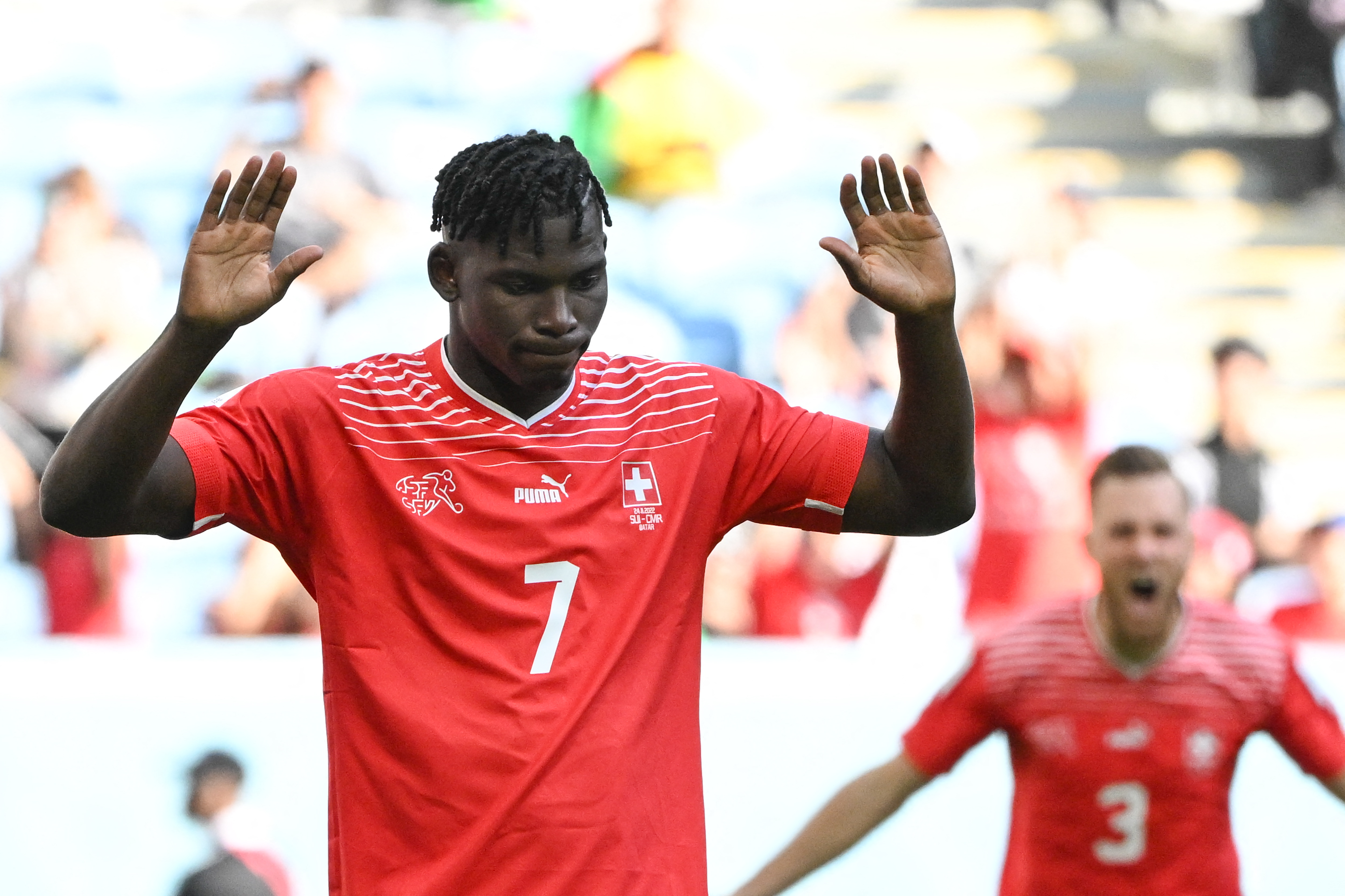 Switzerland's Breel Embolo raises his hand after scoring against his native Cameroon at the World Cup.