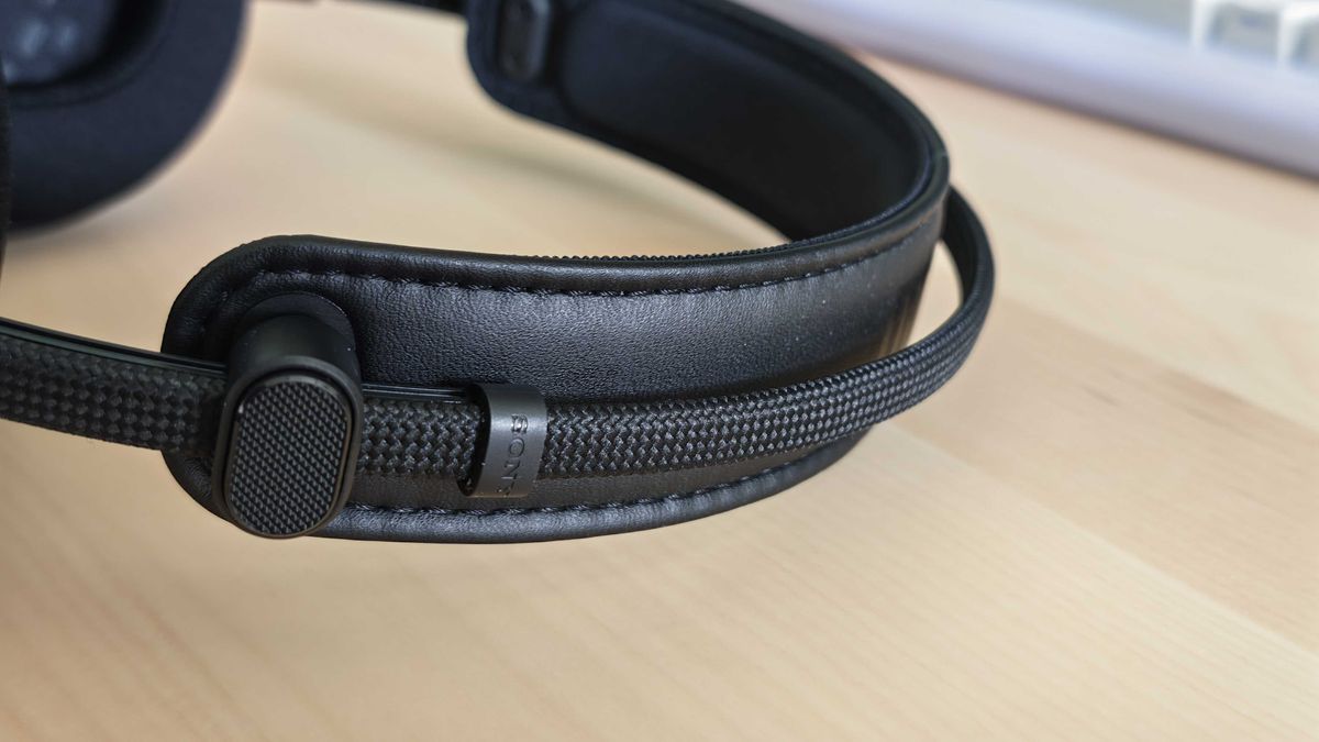 A photo of the Inzone H6 Air gaming headset positioned above a wooden desktop surface.
