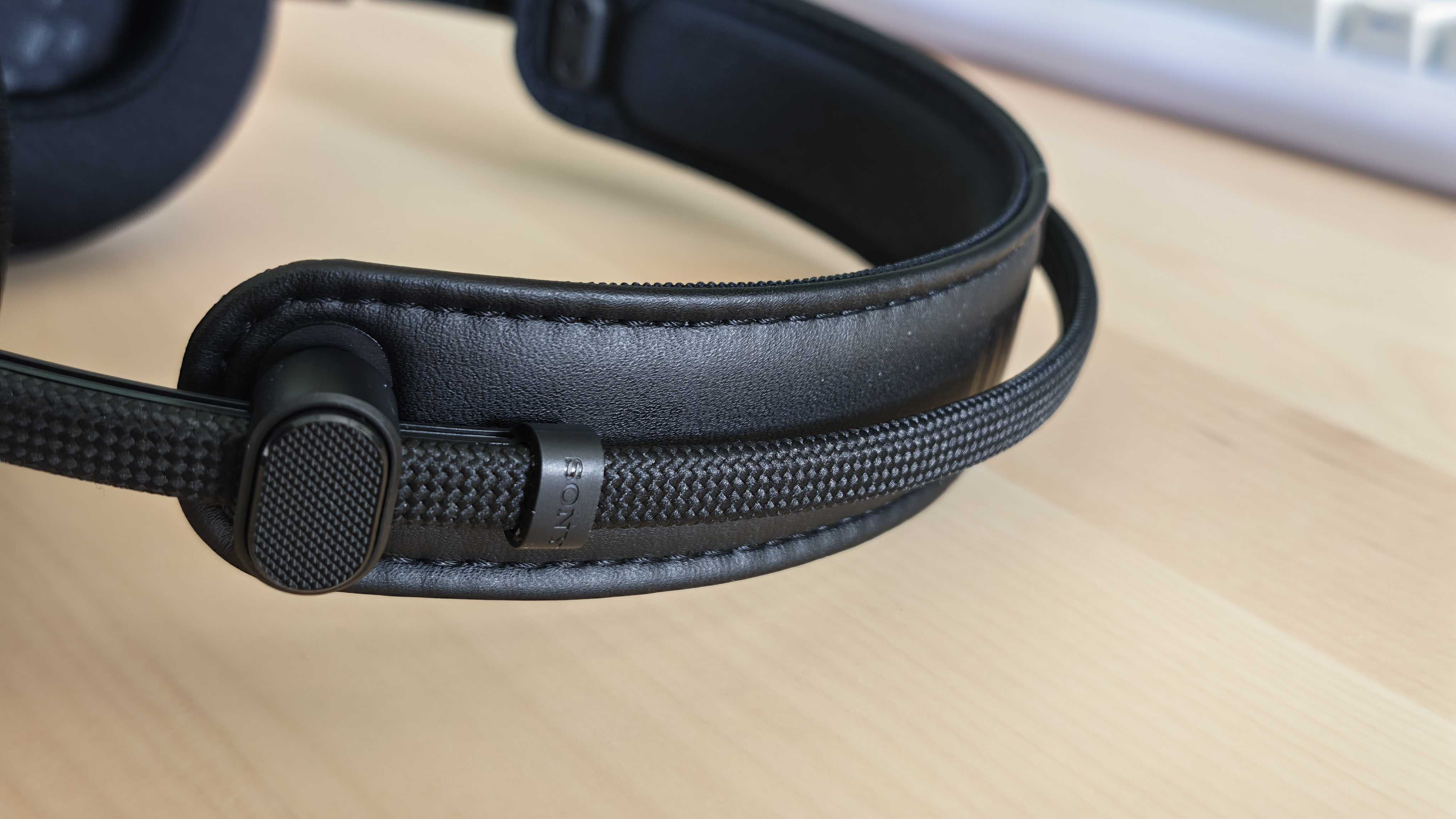 A photo of the Inzone H6 Air gaming headset positioned above a wooden desktop surface.