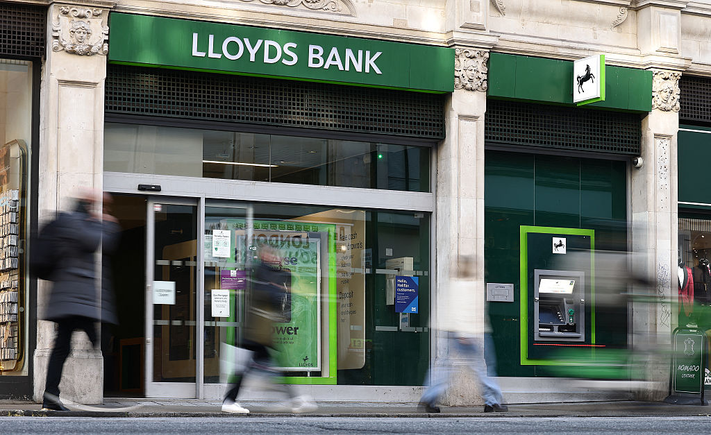 Pedestrians walk past a branch of a Lloyds bank in London 