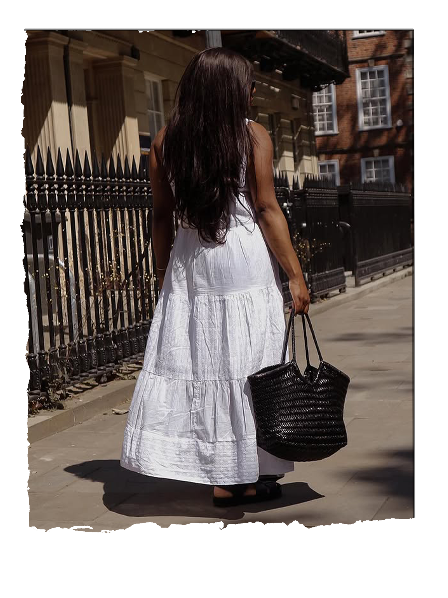 @_loissterling carries a brown Dragon Diffusion basket bag whilst wearing a white cotton maxi dress
