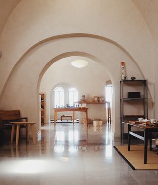 Interior of room with arched walls and wooden tables and chairs
