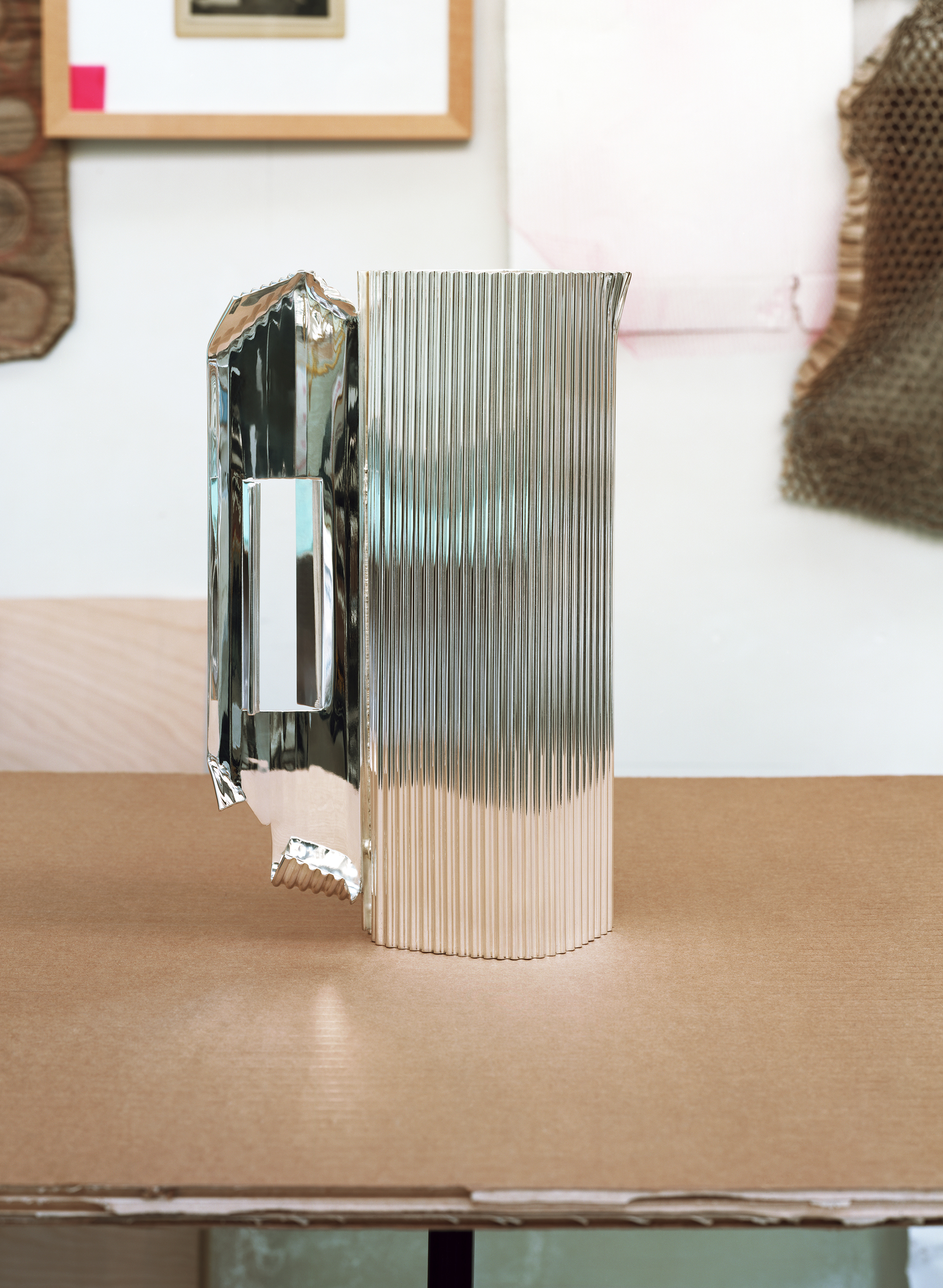 Silver objects with a ridged surface, shown in the context of a messy artist&#039;s studio