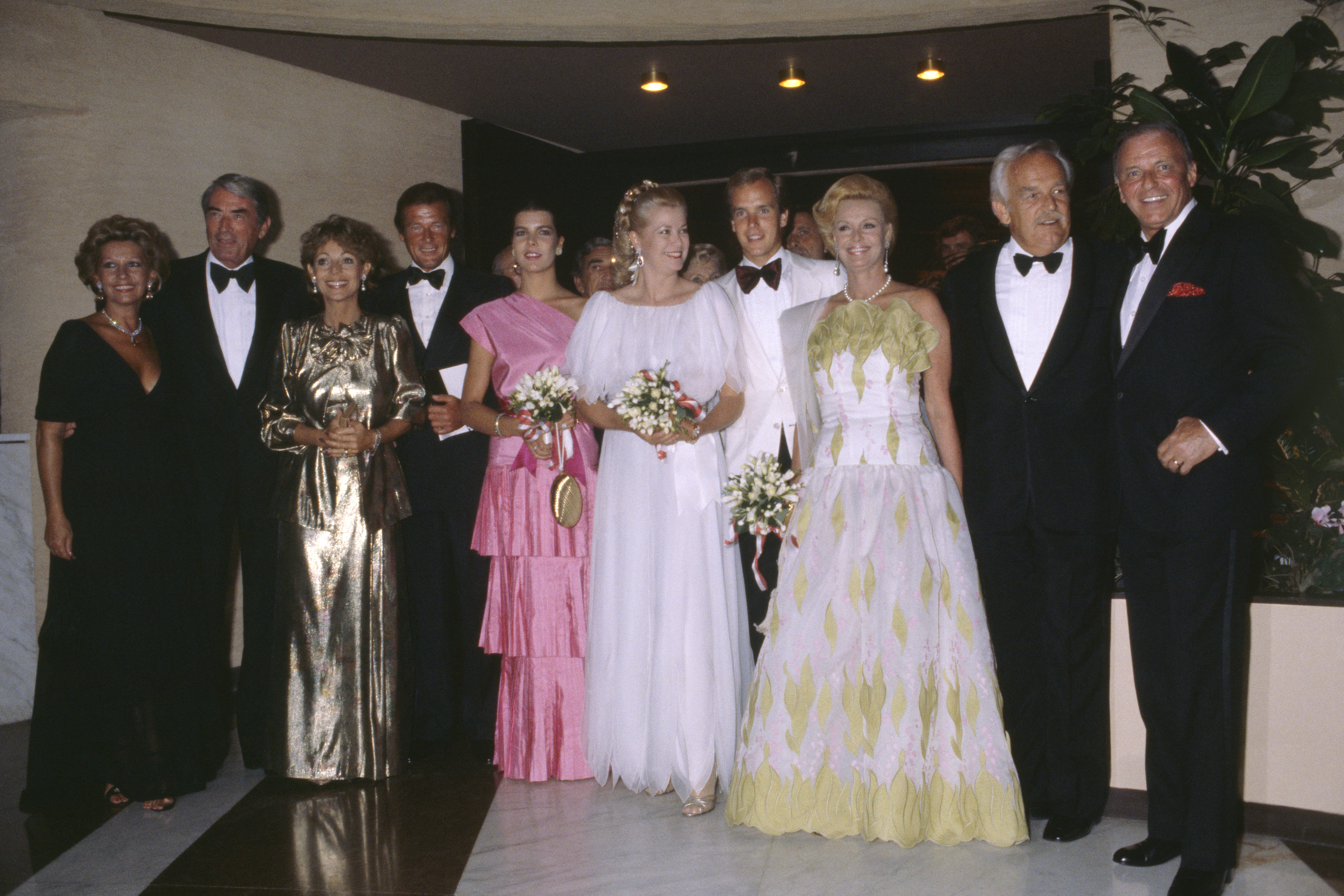 Grace Kelly and Prince Albert, other guests, posing with Frank Sinatra at a ball