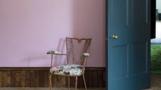 Pink painted hallway with blue chair