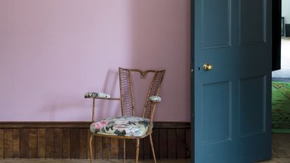 Pink painted hallway with blue chair