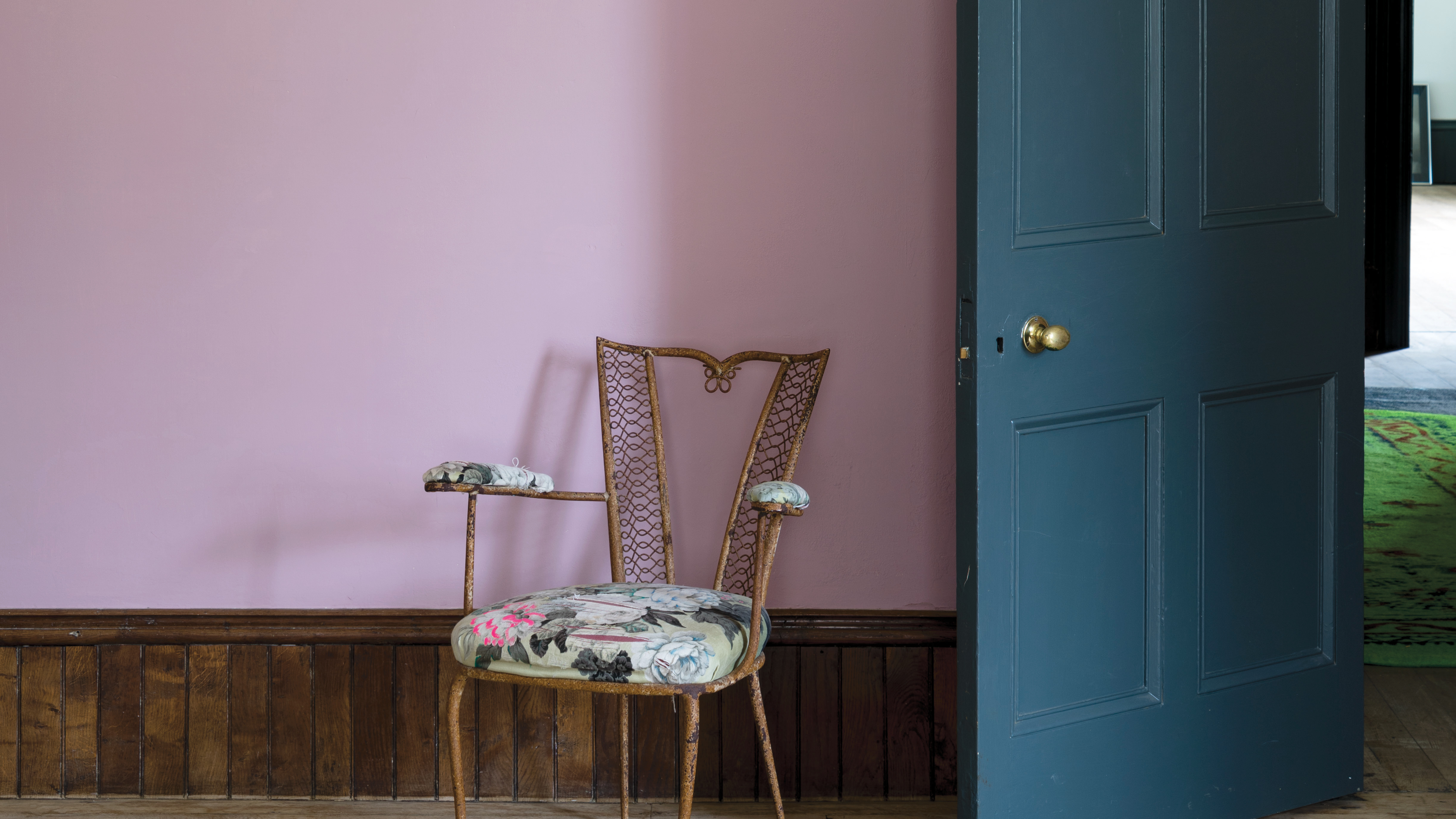 Pink painted hallway with blue chair