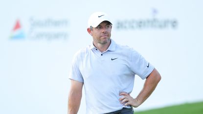 A stern-looking Rory McIlroy watches on with a hand on his hip