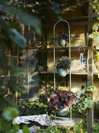 A backyard area with a vertical planter tower and handheld gardening tools