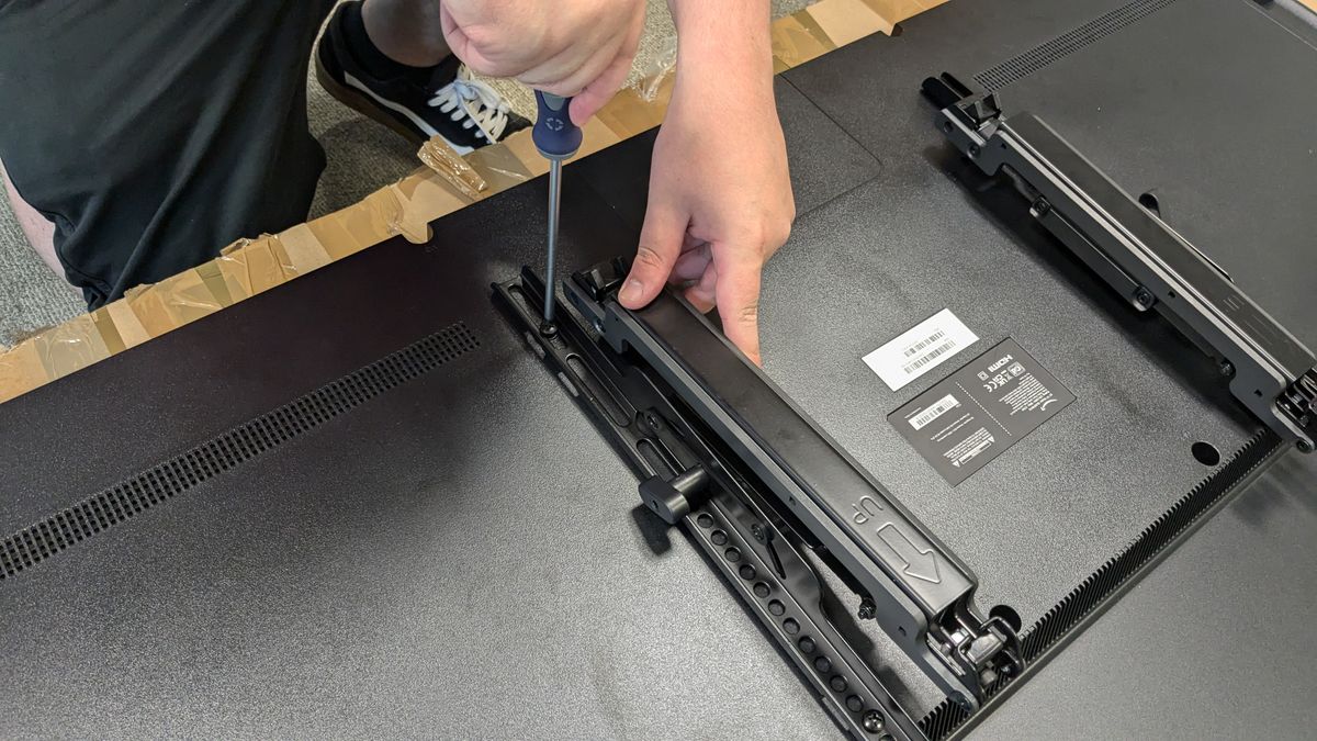 Sanus OLT7 brackets with person using screwdriver