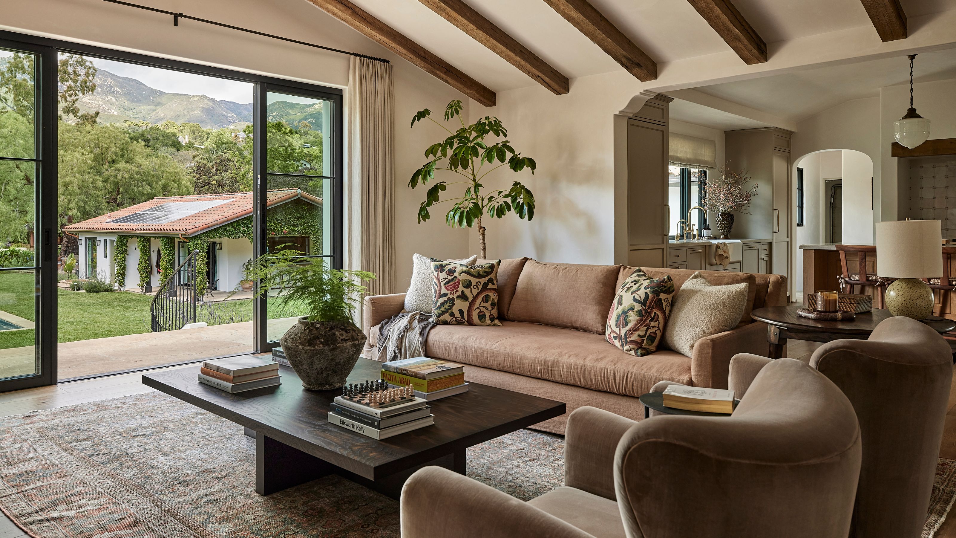 a large open plan Santa Barbara home with vaulted ceiling, patio doors out to a pool area and casita
