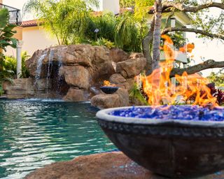 pool grotto with fire bowls and waterfall