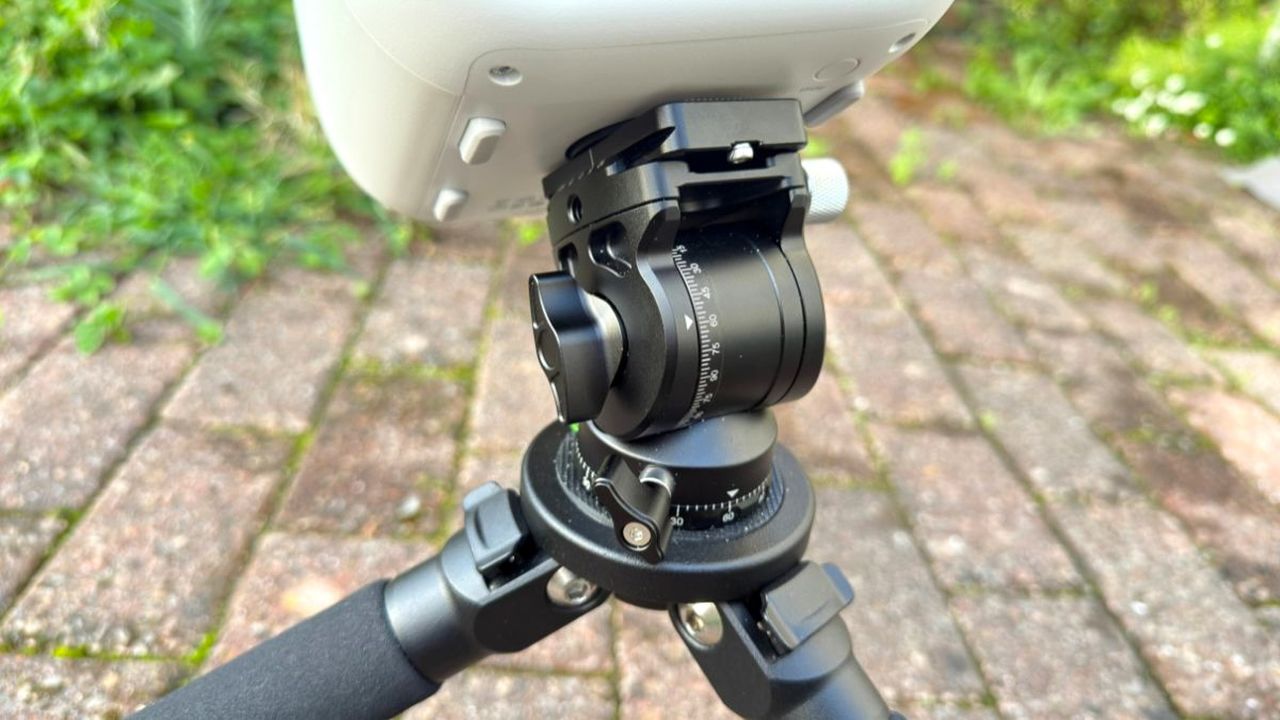The ZWO Seestar TH10 fluid head attached to the ZWO Seestar S50 Pro and tripod with a brick floor in the background.
