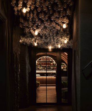 low lit corridor with lightbulb ceiling leading to bar